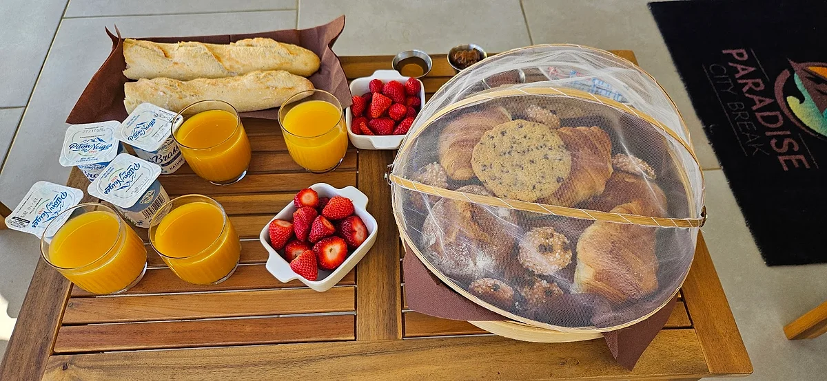 Le plateau du petit déjeuner : viennoiseries, fraises, jus de fruits frais