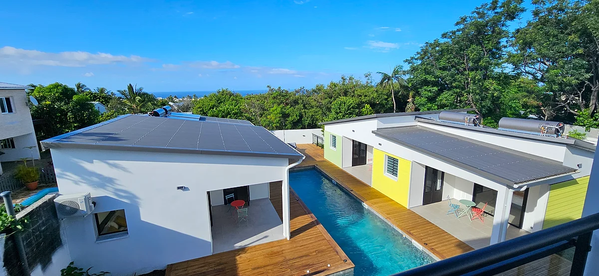 Le Paradise City Break vu du ciel : les suites colorées autour de la piscine, et l'océan au loin